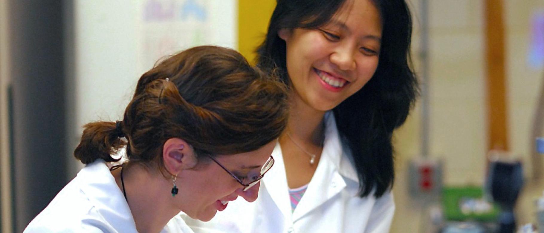 Ling Cao assists a student in a 研究 lab